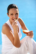 Woman eating bread at a poolside