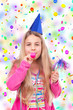 girl with party hat and party horn blower