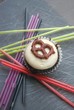 A chocolate cupcake with vanilla frosting and a pretzel A chocolate cupcake with vanilla frosting and a pretzel