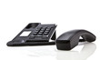 Modern black telephone with handset laying down on white