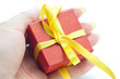 red gift box with a yellow ribbon in the hand of women