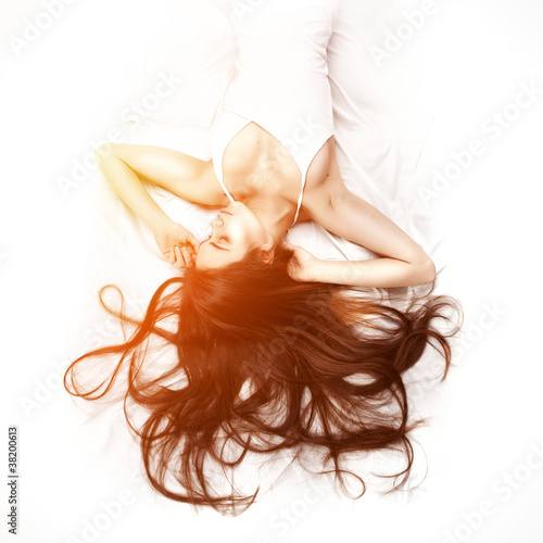 Photo: Beautiful woman lying down in bed Beautiful woman lying down in bed