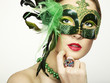 The beautiful young woman in a green mysterious venetian mask The beautiful young woman in a green mysterious venetian mask