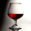 Glass of cognac on grey background