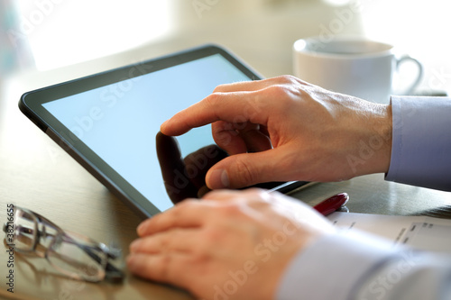 Photo: Finge touching screen of a digital tablet Finge touching screen of a digital tablet