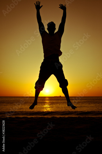 Photo: Silhouette of a man jumping on the beach at sunset Silhouette of a man jumping on the beach at sunset