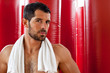 Handsome muscular man sweating with towel on his shoulders