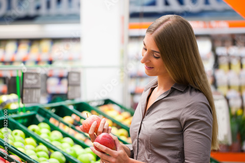 Photo: Fit Woman Buying Apples at Supermarket Fit Woman Buying Apples at Supermarket