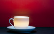 A lighting white cup in front of red background A lighting white cup in front of red background