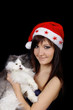 Young woman in santa cap with cat