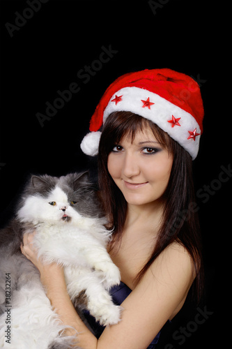 Photo: Young woman in santa cap with cat Young woman in santa cap with cat