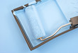 Paint roller with blue paint in tray