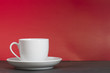 A white cup in front of red background A white cup in front of red background