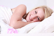 junge frau lachend im bett liegend