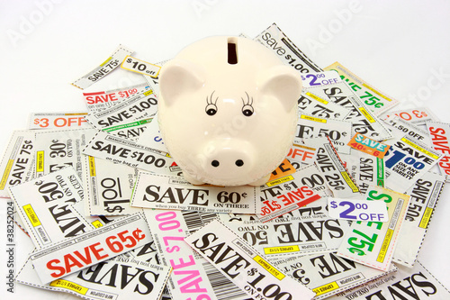 Photo: Piggy Bank On Pile Of Money Saving Grocery Coupons Piggy Bank On Pile Of Money Saving Grocery Coupons