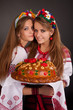 Young women in ukrainian clothes, with garland and round loaf on