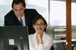 Co-workers in front of desktop computer