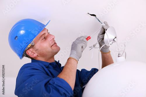 Foto: Electrician wiring a ceiling light Electrician wiring a ceiling light
