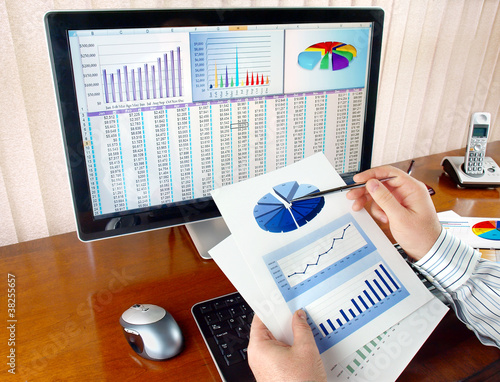 Photo: Businessman analyzing investment charts at his workplace Businessman analyzing investment charts at his workplace