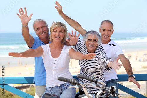 Photo: happy foursome gone for a ride by oceanfront happy foursome gone for a ride by oceanfront