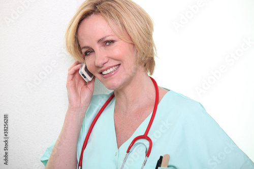 Photo: Female nurse speaking on mobile telephone Female nurse speaking on mobile telephone