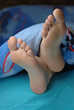 Female feet put out from the blanket Female feet put out from the blanket