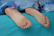 Female feet put out from the blanket Female feet put out from the blanket