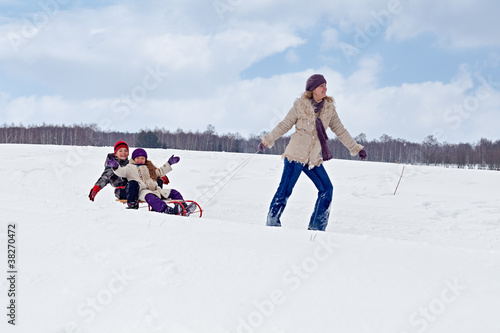 Photo: Children sleigh riding - their mother helping Children sleigh riding - their mother helping