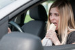 Portrait of young woman eating while driving car