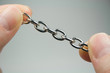 Small Metal Chain held Between Fingers