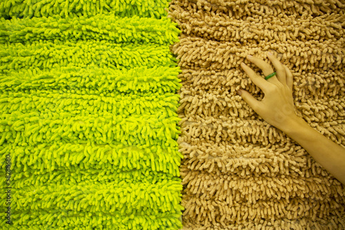 Photo: touch towel, hand touching brown towel in stack. touch towel, hand touching brown towel in stack.