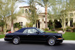 Convertible car standing outside of a luxury house