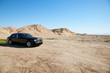 Black eco-friendly Rolls Royce car running off-road on unpaved road