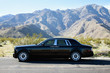 Rolls Royce travelling on country road in front of mountains