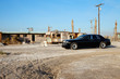 Rolls Royce parked in front of abandoned houses