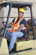 Forklift driver driving in warehouse