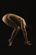 Side profile of a naked woman exercising