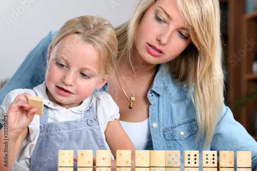 Foto: Young girl playing with dominoes Young girl playing with dominoes