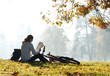 Woman cyclist with read the map sitting among the green scenery