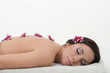 Young beautiful woman with chrysanthemums relaxing on the towel.