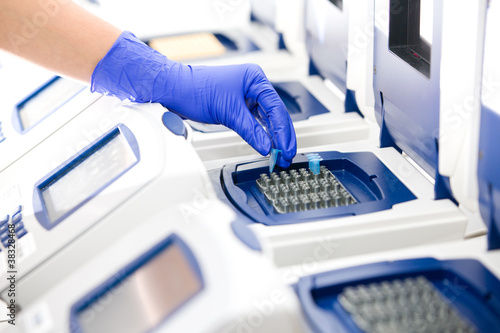 Photo: Scientist with DNA copying, Real-time cycler, wide Scientist with DNA copying, Real-time cycler, wide