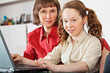 Girl and her mother with laptop at home