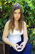 Foto: young high school girl with mobile prepaid smart phone in garden young high school girl with mobile prepaid smart phone in garden