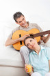 Mann spielt Gitarre für Frau