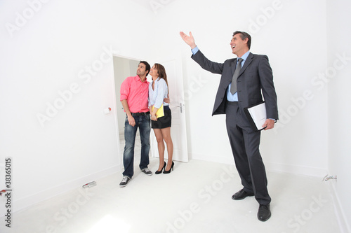 Photo: Couple being shown around property by estate-agent Couple being shown around property by estate-agent