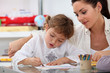 Teacher watching her pupil colouring a drawing