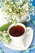 tea in a cup of white flowers and lilies of the valley