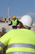 Construction worker watching his colleague using a yardstick