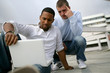 Two men outdoors with computer