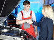 Motor mechanic and customer shaking hands for good deal